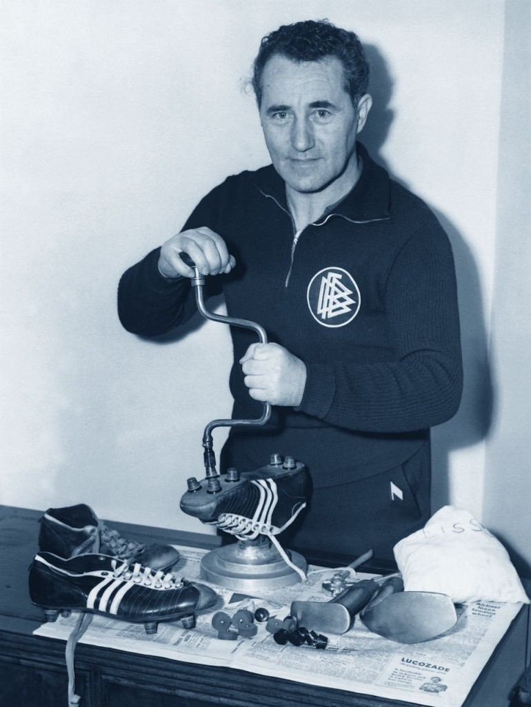 Adolf Dassler mentre sistema i tacchetti di un paio di scarpe da calcio