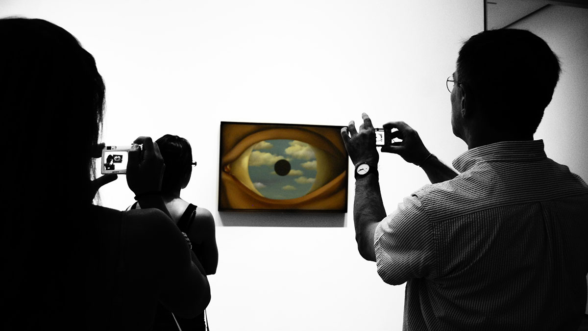 Persone fotografano Il falso specchio di Magritte al MoMA
